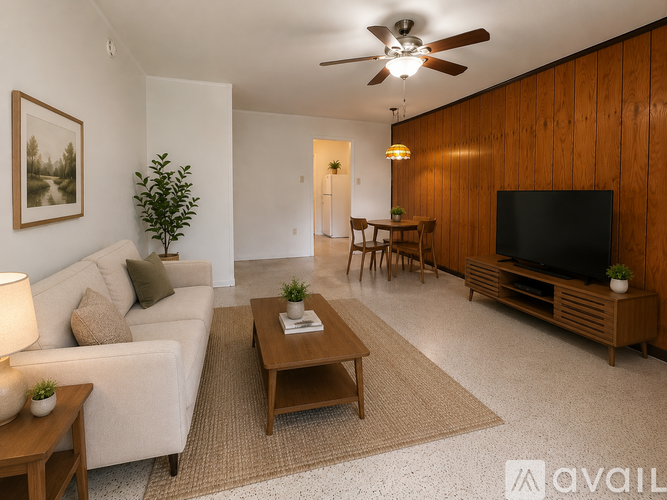 A living room with a white couch, a wooden coffee table, a flat screen TV, and a ceiling fan.