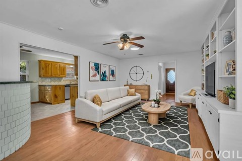 A living room with a white couch and a wooden coffee table.