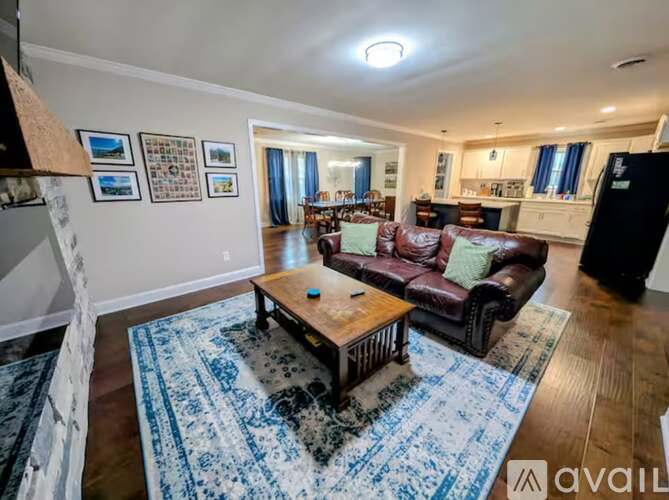 A living room with a brown leather couch and a wooden coffee table.
