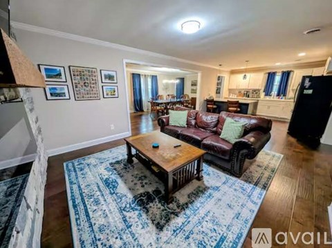 A living room with a brown leather couch and a wooden coffee table.