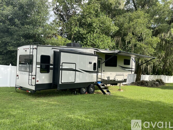 A white RV is parked in a grassy area.