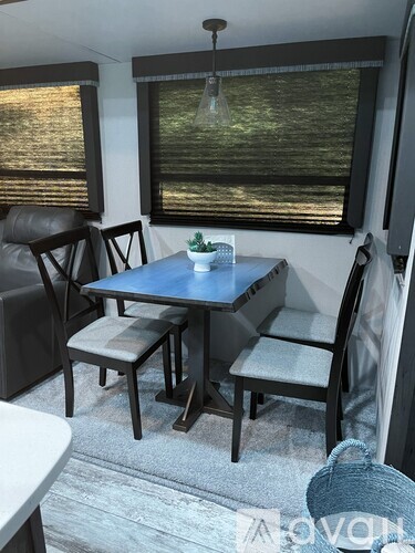 A dining table with four chairs and a basket on the floor.