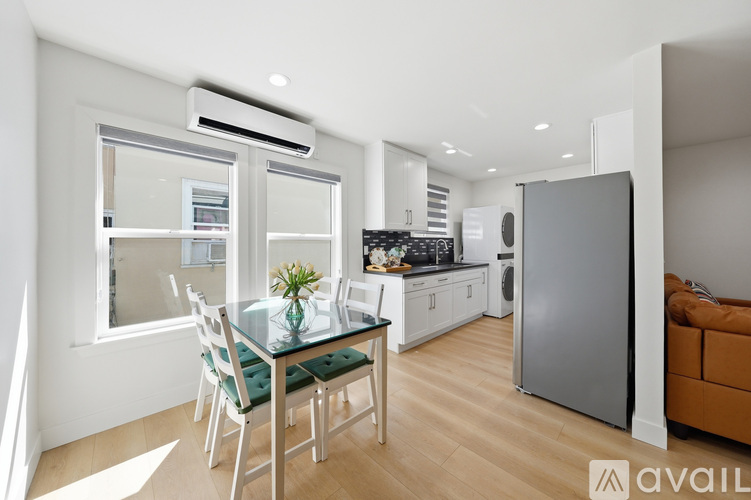 A modern kitchen with a glass dining table and chairs.