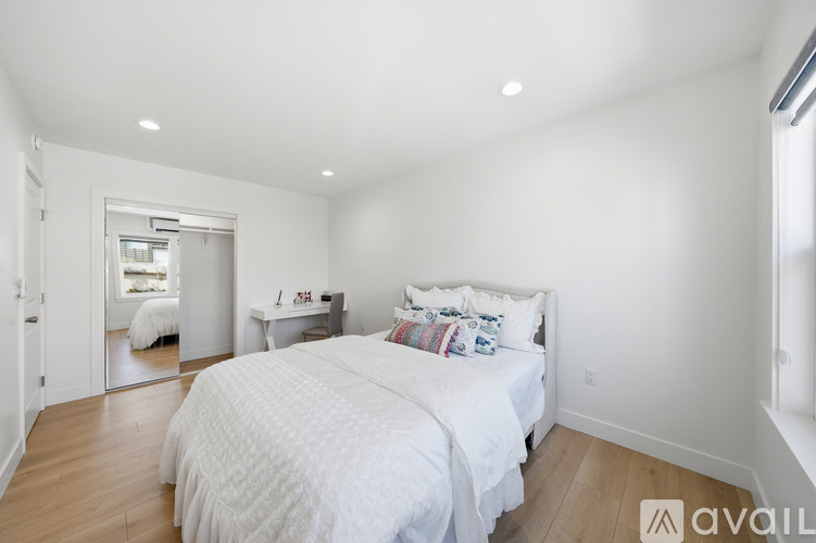 A bedroom with a large bed and a small sitting area.