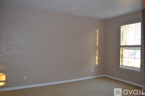 A room with a window and a carpet on the floor.
