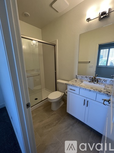 A bathroom with a toilet, sink, and mirror.