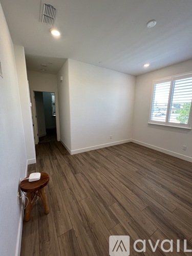A room with wooden flooring and a window with blinds.