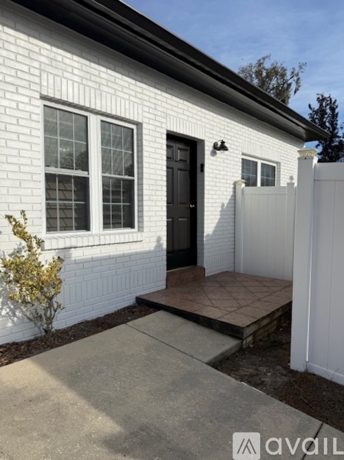 A white house with a black door and a small porch.