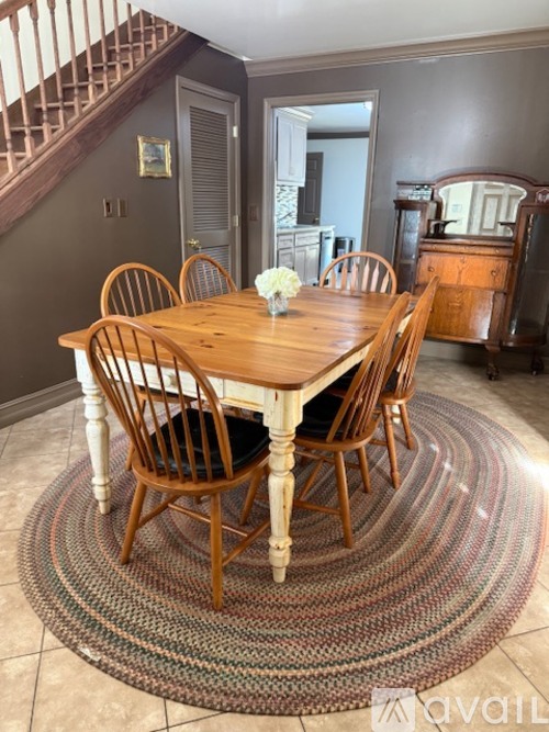 A dining room with a wooden table and chairs.