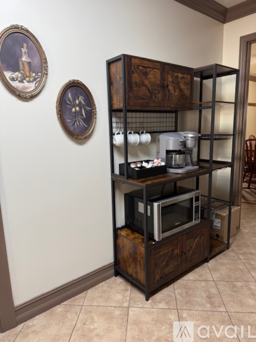 A kitchen cabinet with a microwave and a coffee maker.