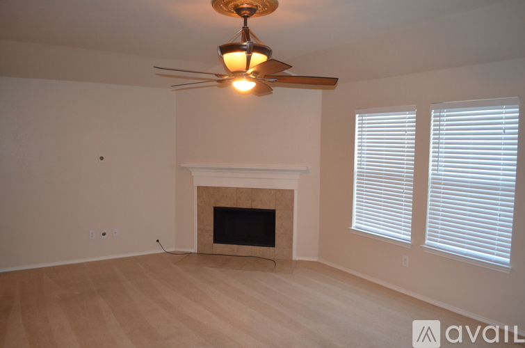 A room with a fireplace and a ceiling fan.