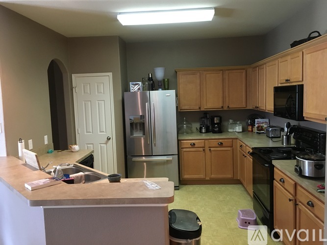 A kitchen with a refrigerator, microwave, and oven.