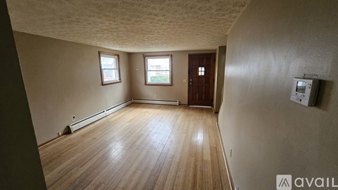 A room with wooden flooring and a window.