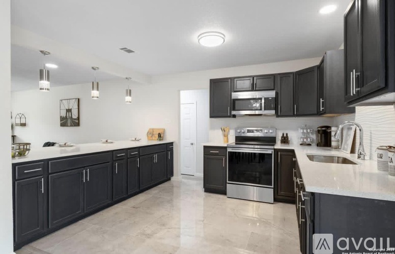 A kitchen with black cabinets and stainless steel appliances.