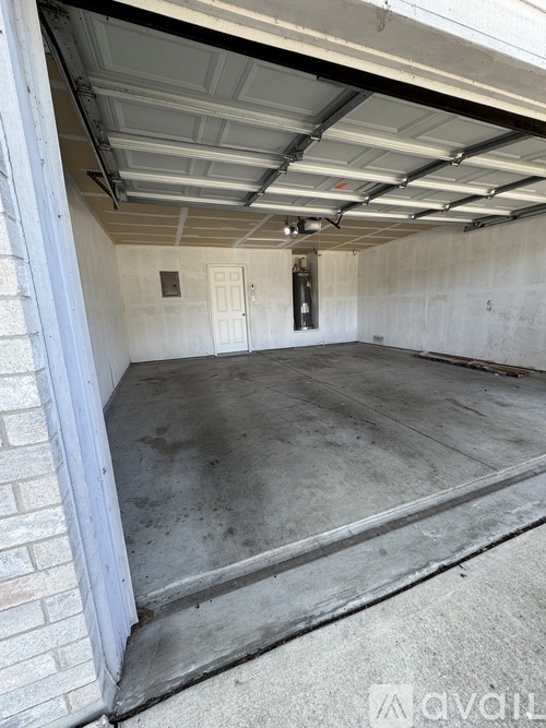 A spacious garage with a white door and a concrete floor.