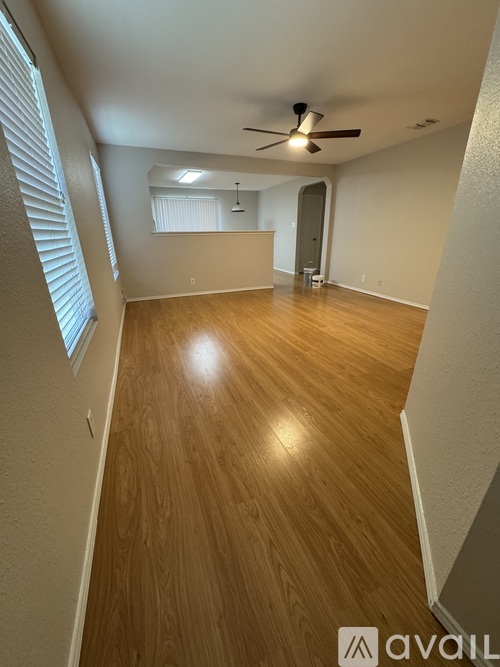 A room with wooden flooring and a ceiling fan.