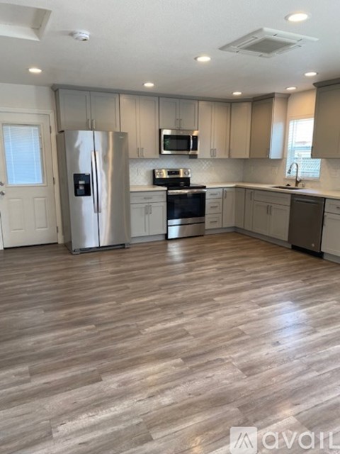 A kitchen with wooden floors and stainless steel appliances.