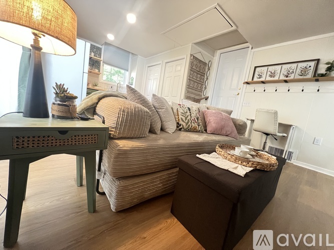 A living room with a couch, a table, and a lamp.