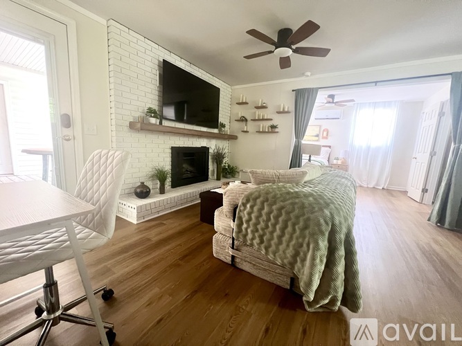 A living room with a fireplace and a television mounted above it.
