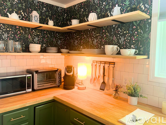 A kitchen with green cabinets and a wooden countertop.