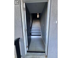 A hallway with a black door and a sign that says "REALTOR".