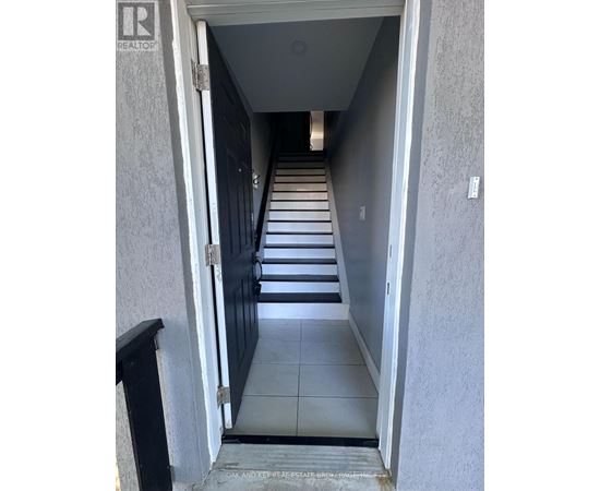 A hallway with a black door and a sign that says "REALTOR".