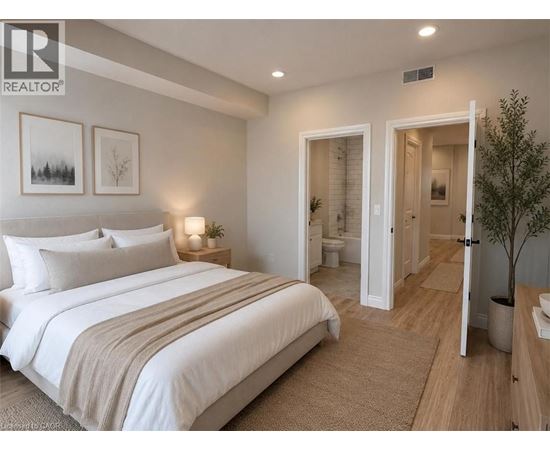 A bedroom with a large bed and a small tree.