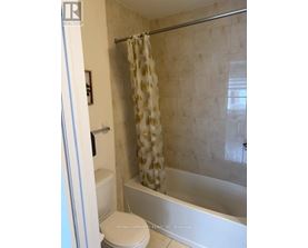 A bathroom with a toilet, shower, and a shower curtain.
