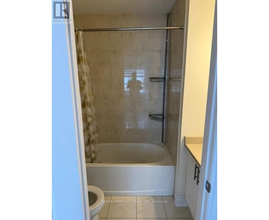A white bathroom with a toilet, tub, and shower.