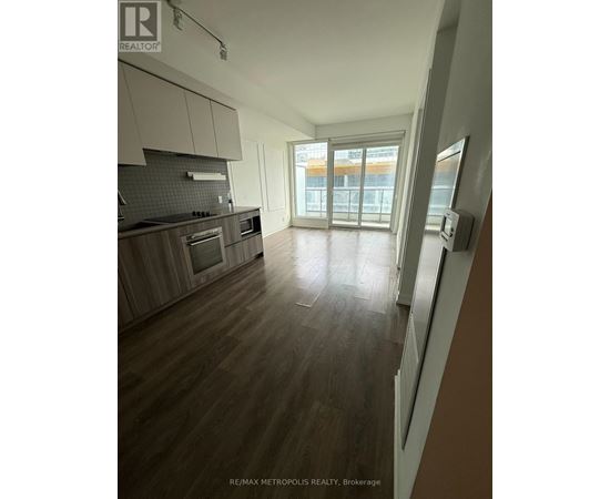 A spacious kitchen with wooden floors and modern appliances.
