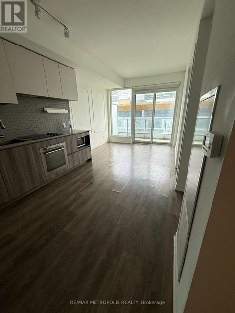 A spacious kitchen with wooden floors and modern appliances.
