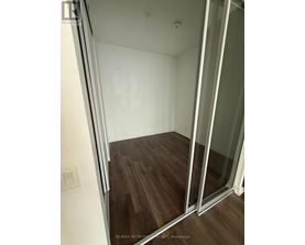 A room with a sliding glass door and wood flooring.