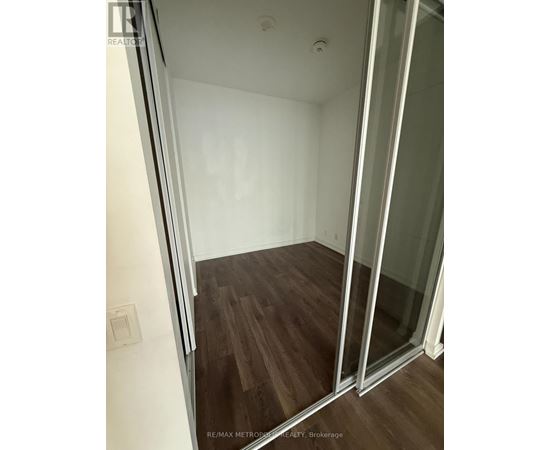 A room with a sliding glass door and wood flooring.