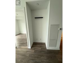 A room with a white door and a grey wall.