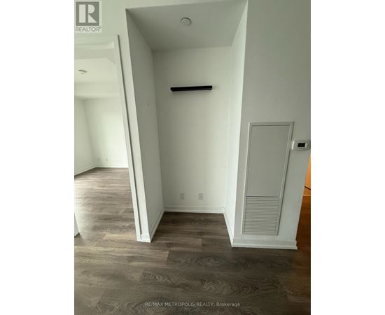 A room with a white door and a grey wall.