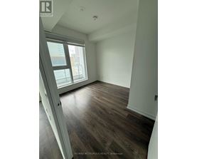 A room with a sliding glass door and wood flooring.