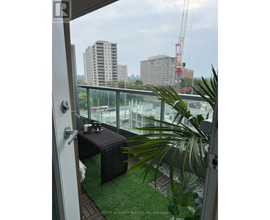 A balcony with a glass railing and a green mat.