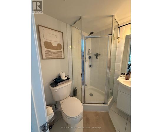 A bathroom with a toilet, sink, and shower.