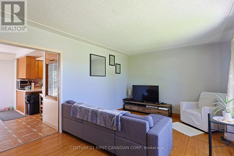 A living room with a grey couch and a television on a wooden stand.