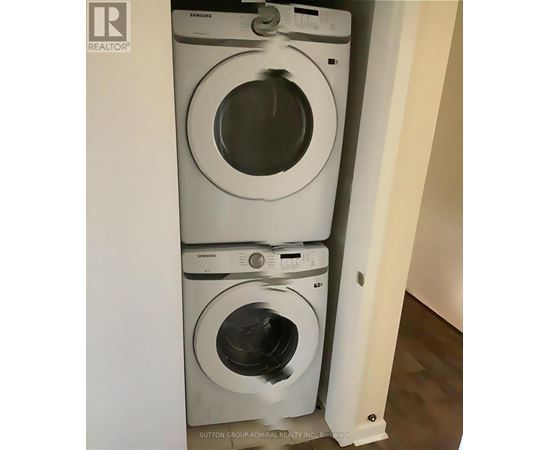 A stack of three white Samsung washing machines in a small space.
