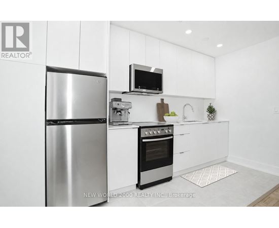 A modern kitchen with a stainless steel refrigerator and an oven.
