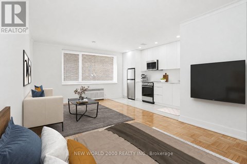 A living room with a white couch and a black coffee table.