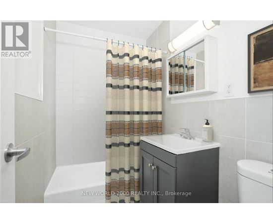 A bathroom with a white tub, a sink, and a shower curtain.