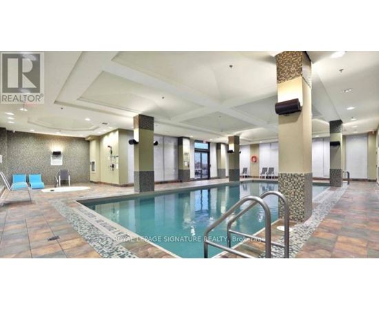 A large indoor swimming pool with a tiled floor and a metal ladder.