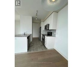 A kitchen with white cabinets and a black microwave.