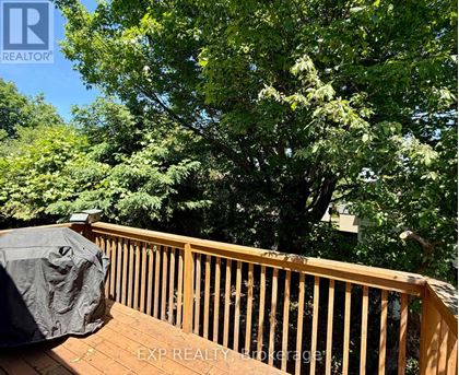A wooden deck with a black cover and trees in the background.