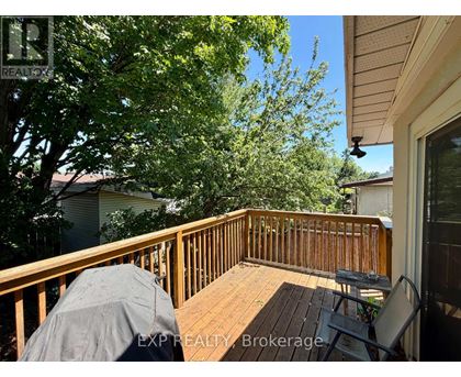 A wooden deck with a table and chairs is covered with a grey tarp.