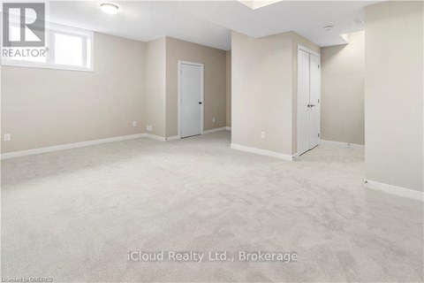 A spacious empty room with two doors and a window.