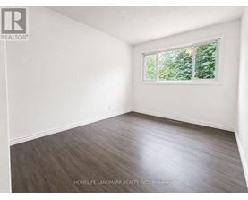 A room with a window and wooden flooring.