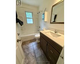 A bathroom with a toilet, sink, and tub.